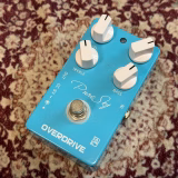 水色のケースと白い4つのノブを備えたCaline Pure Sky Overdrive