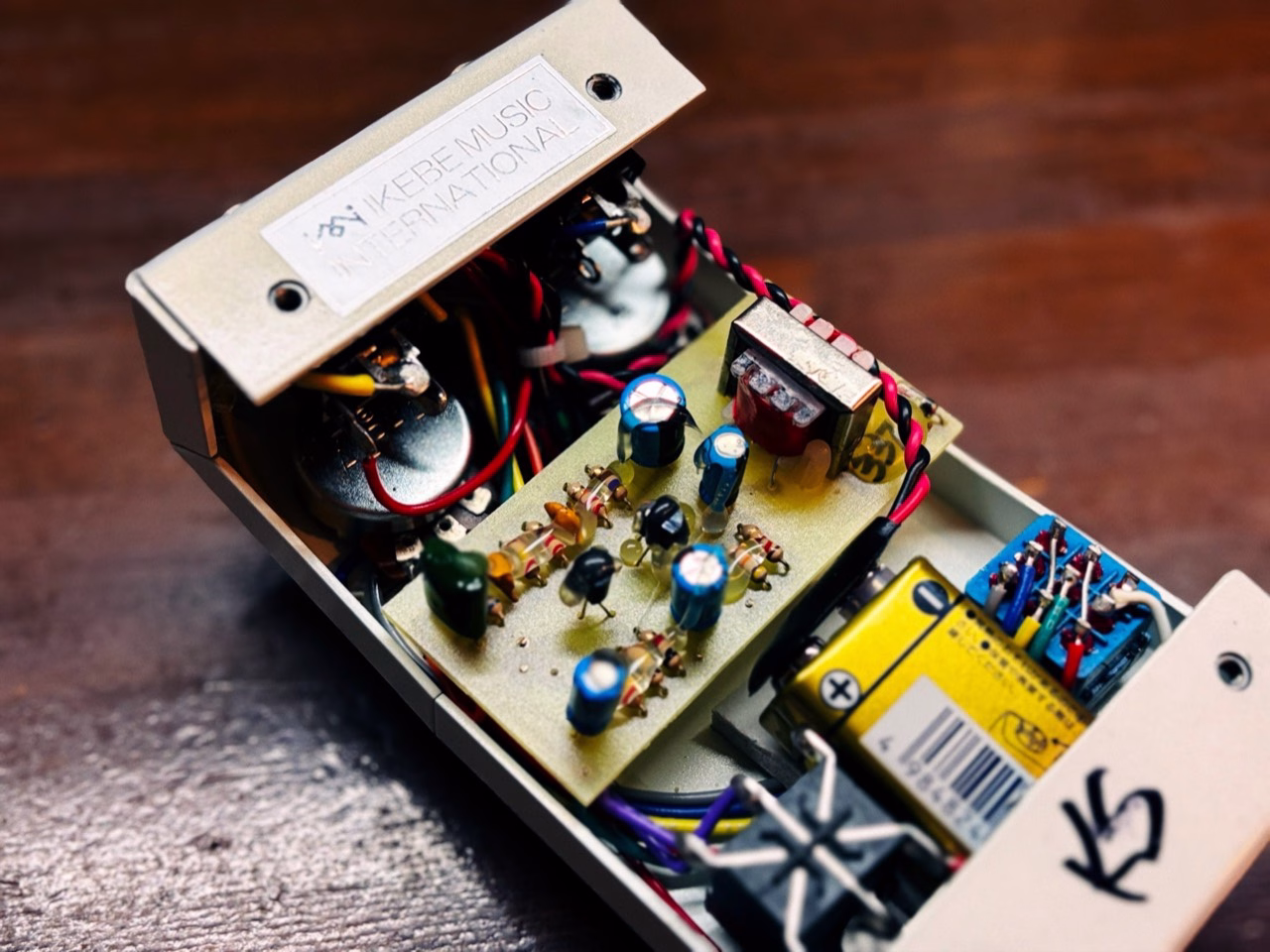 斜めから見たOctavian Plusの内部。基板上のトランス、9V電池とフットスイッチ配線